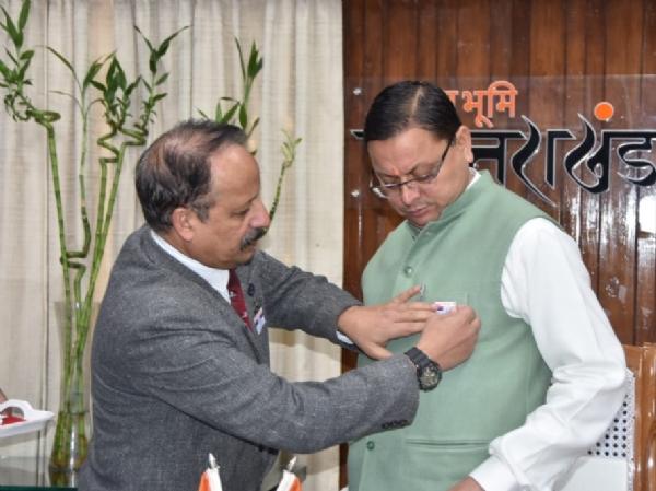 सीएम धामी को सशस्त्र सेना झंडा दिवस पर लगाया फ्लैग